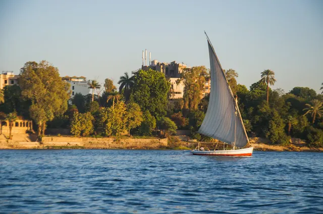 Segelbåt på Nilen med Luxor i bakgrunden.