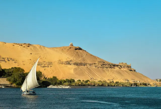 Felucca på Nilen vid Aswan med ökenhöjder i bakgrunden